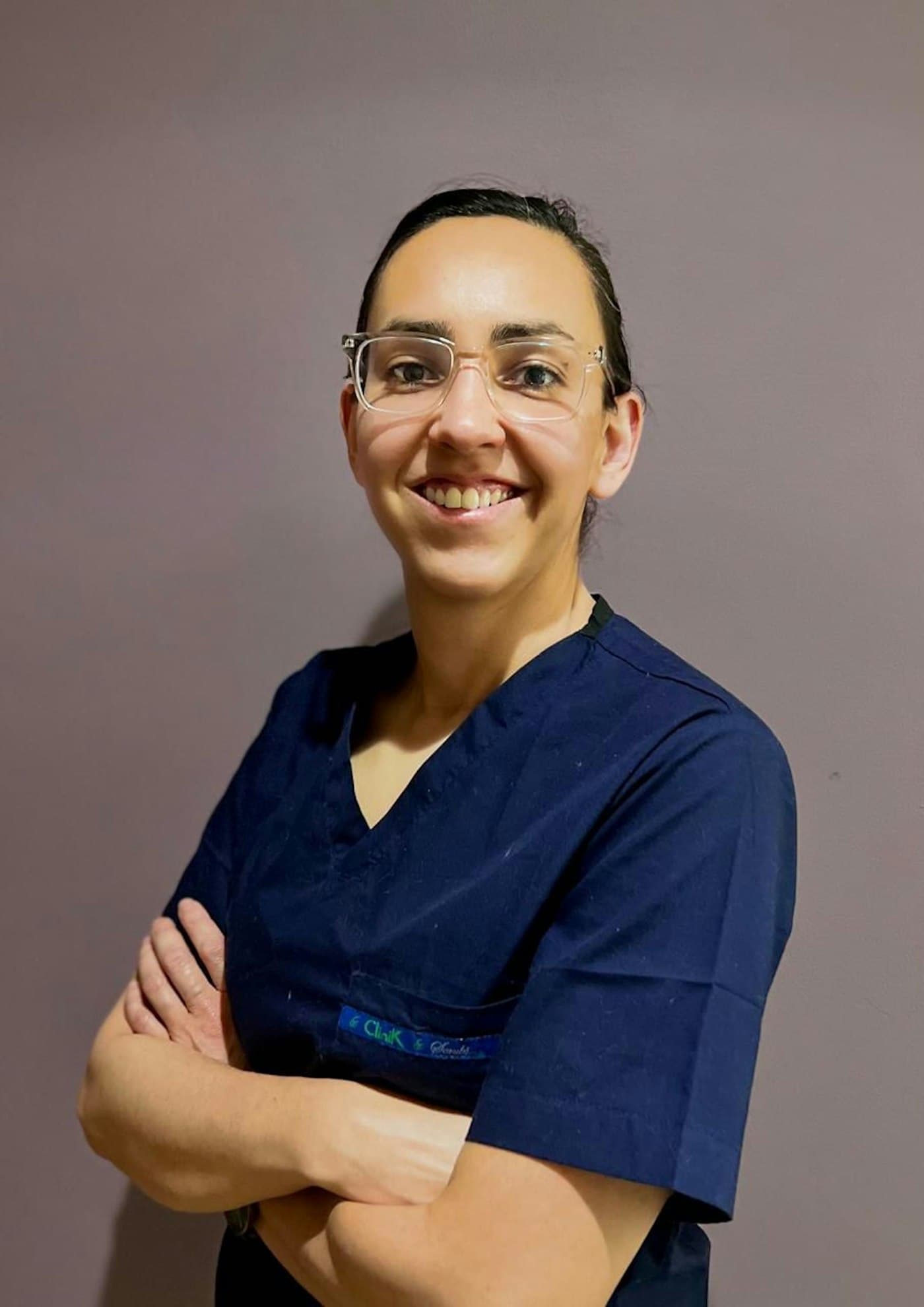 Praticienne souriante, bras croisés